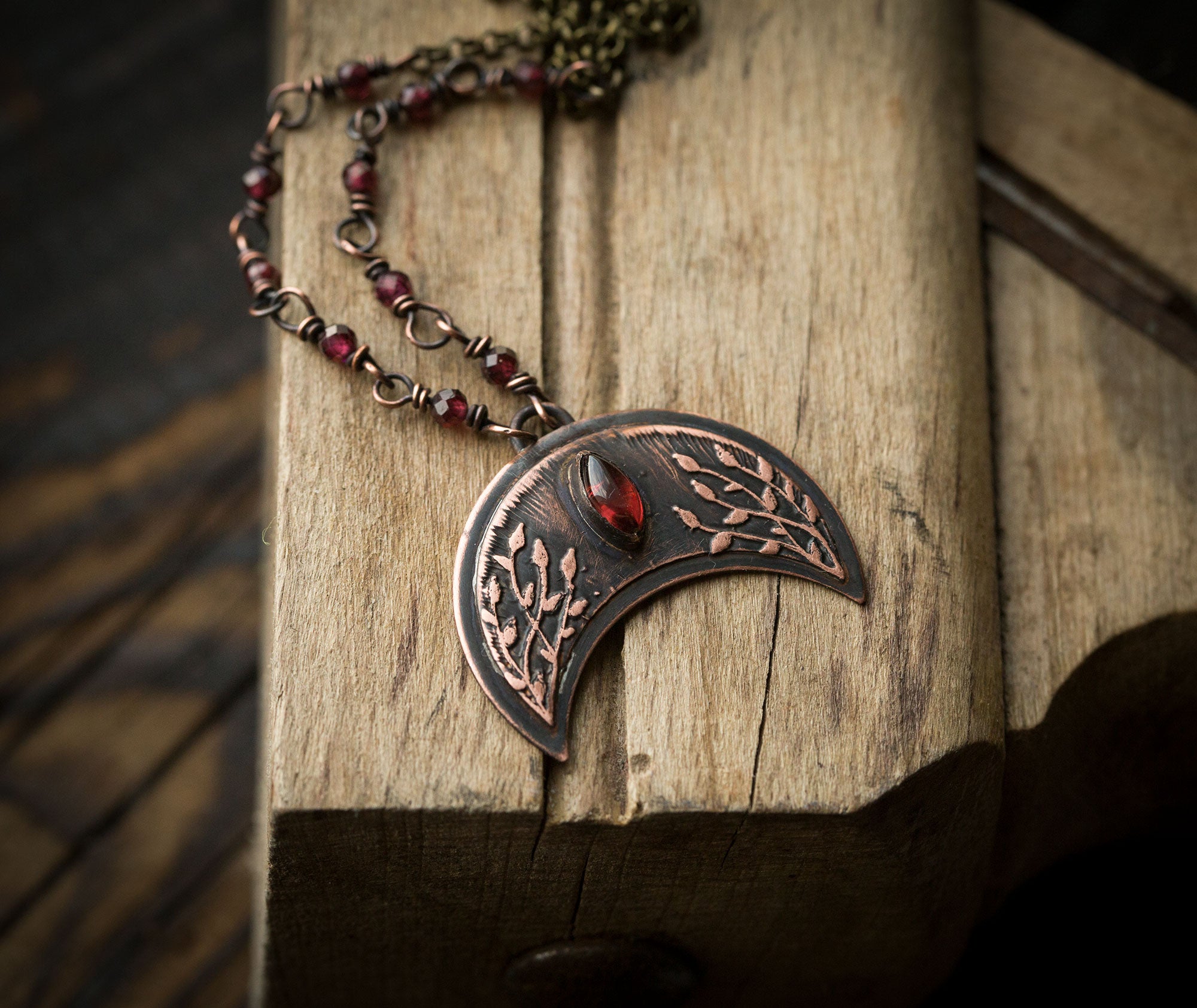 Ciemna lunula z roślinnym rysunkiem i granatami