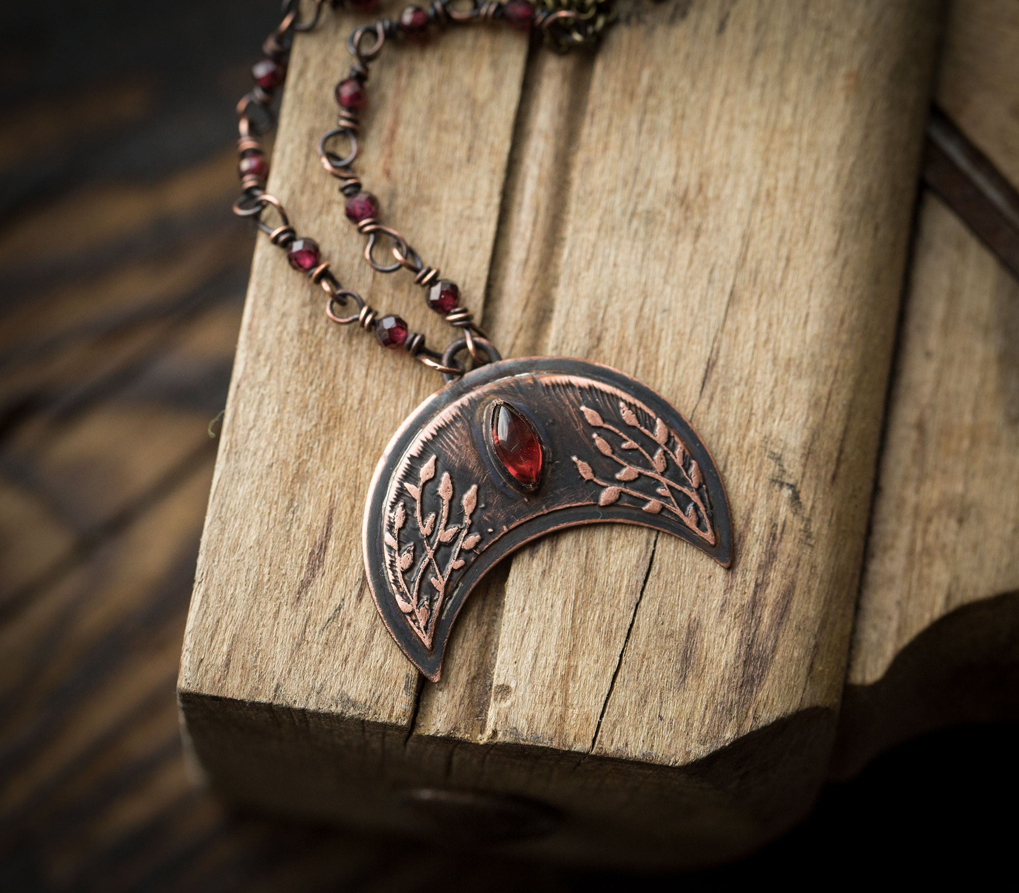 Ciemna lunula z roślinnym rysunkiem i granatami