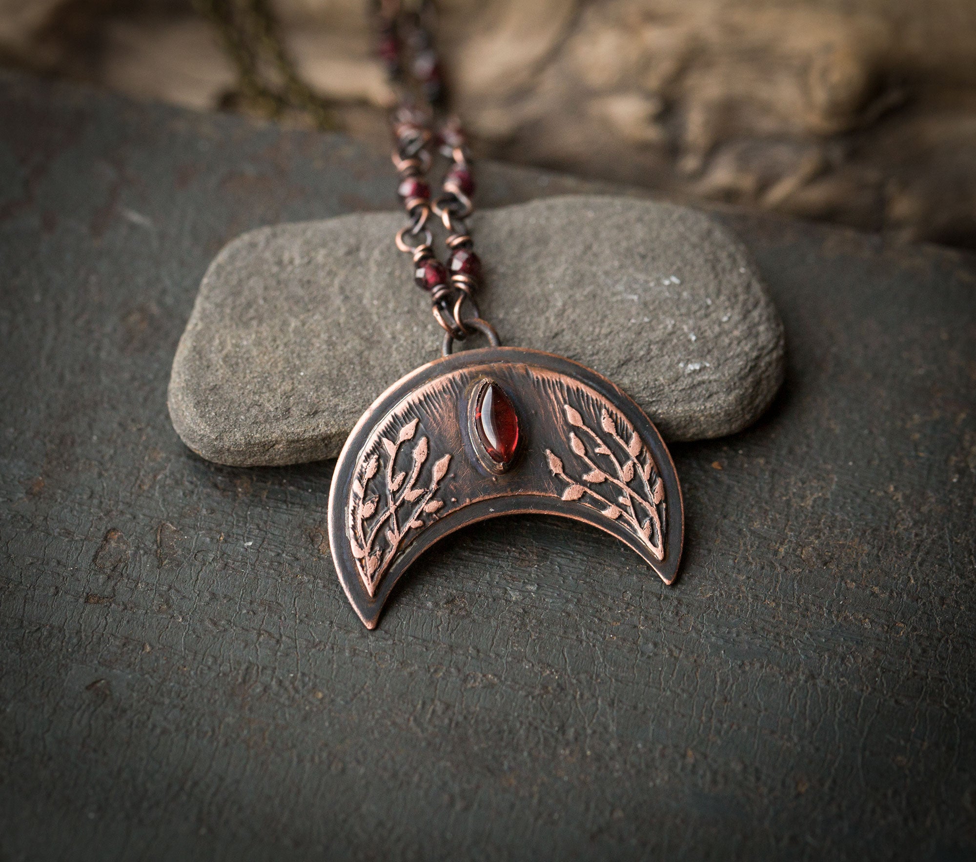 Ciemna lunula z roślinnym rysunkiem i granatami