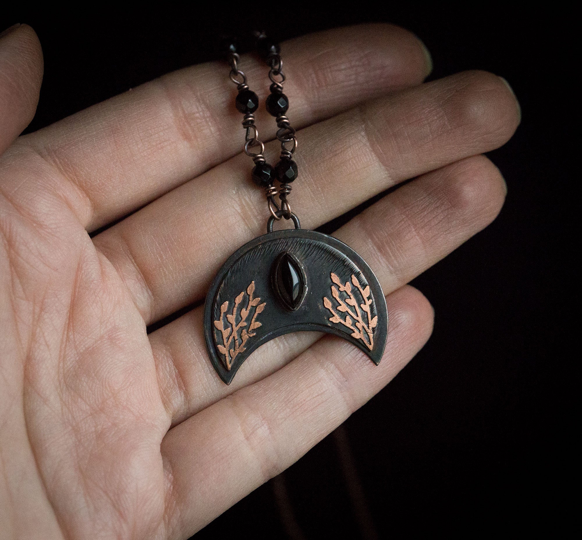 Ciemna lunula z roślinnym rysunkiem i onyksem