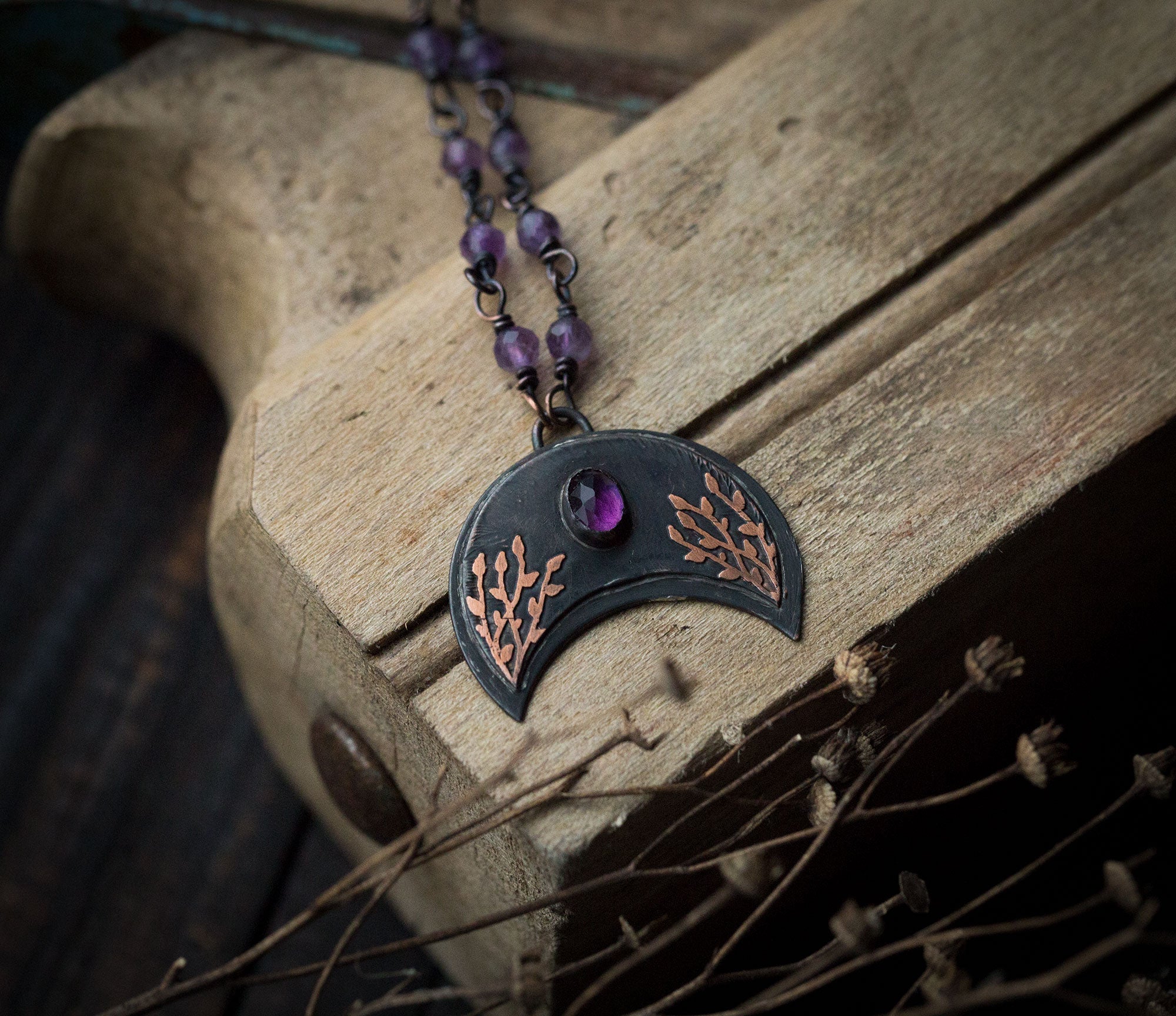 Ciemna lunula z roślinnym rysunkiem i ametystem