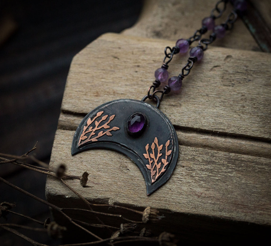 Ciemna lunula z roślinnym rysunkiem i ametystem