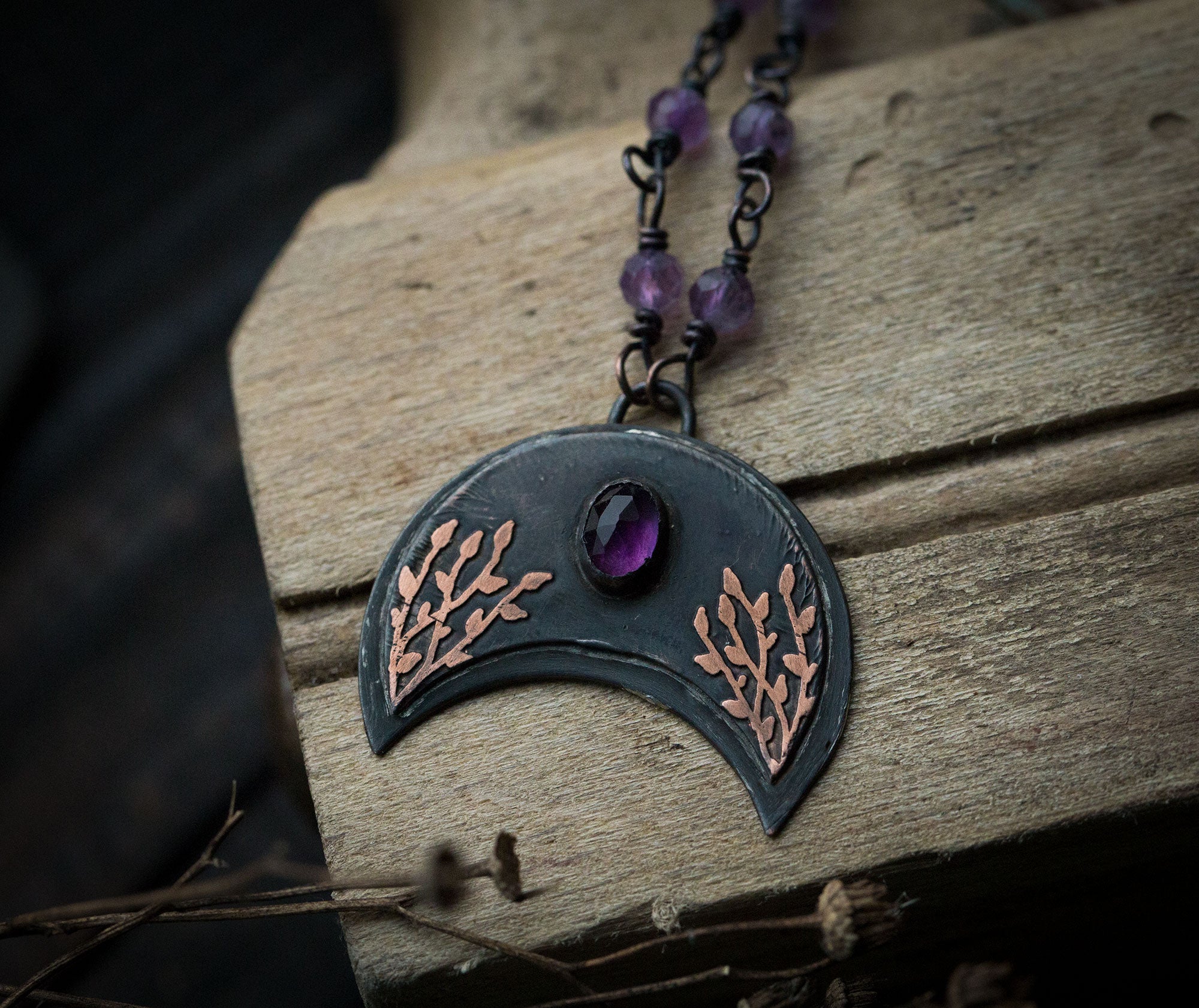 Ciemna lunula z roślinnym rysunkiem i ametystem