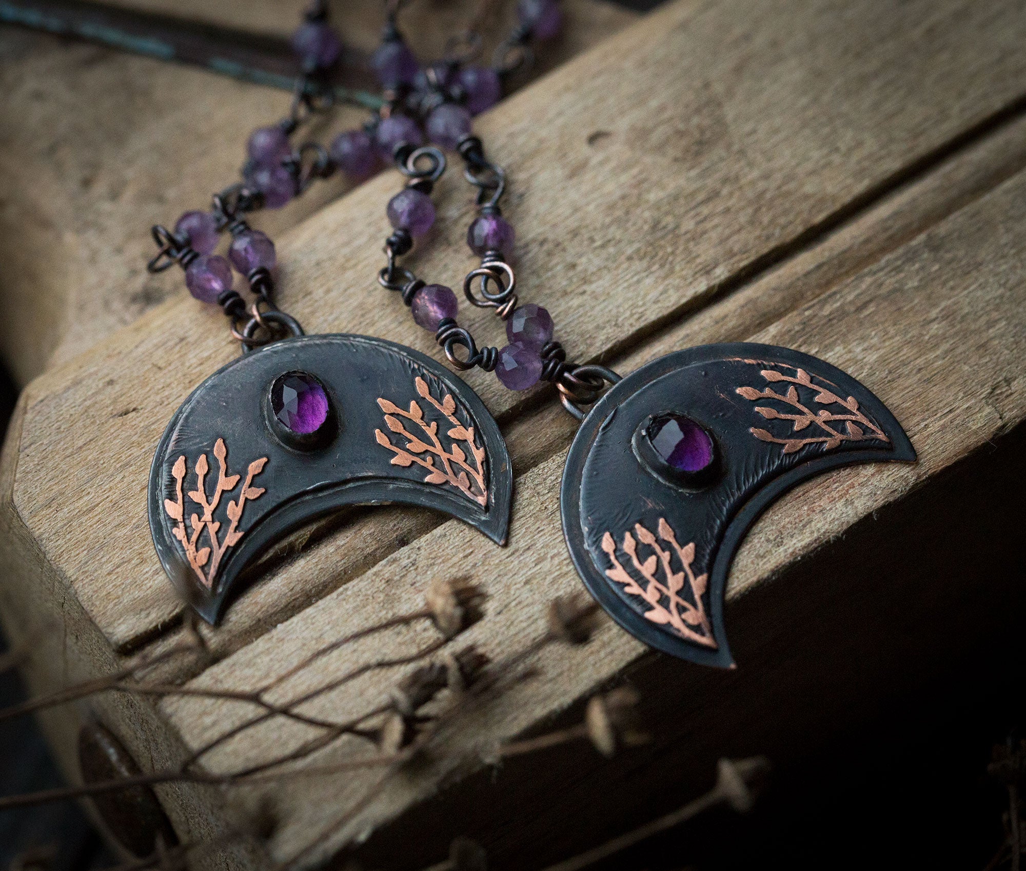 Ciemna lunula z roślinnym rysunkiem i ametystem