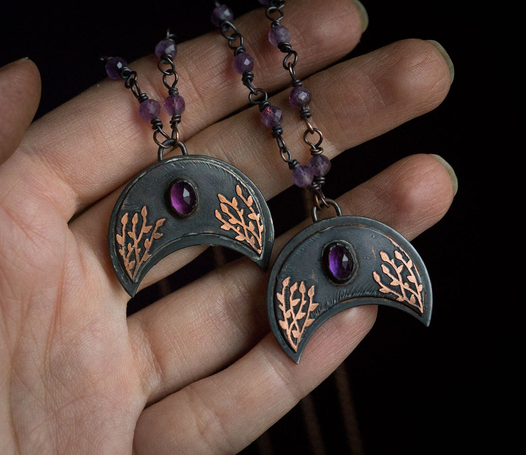 Ciemna lunula z roślinnym rysunkiem i ametystem