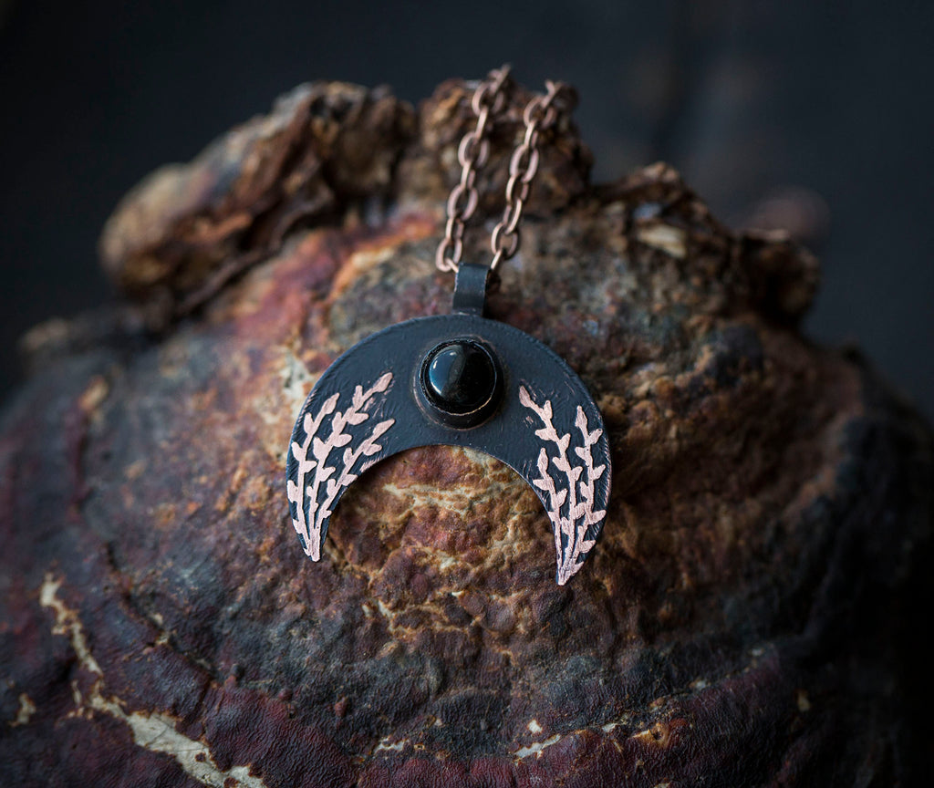 Ciemna lunula z obsydianem i roślinnym rysunkiem