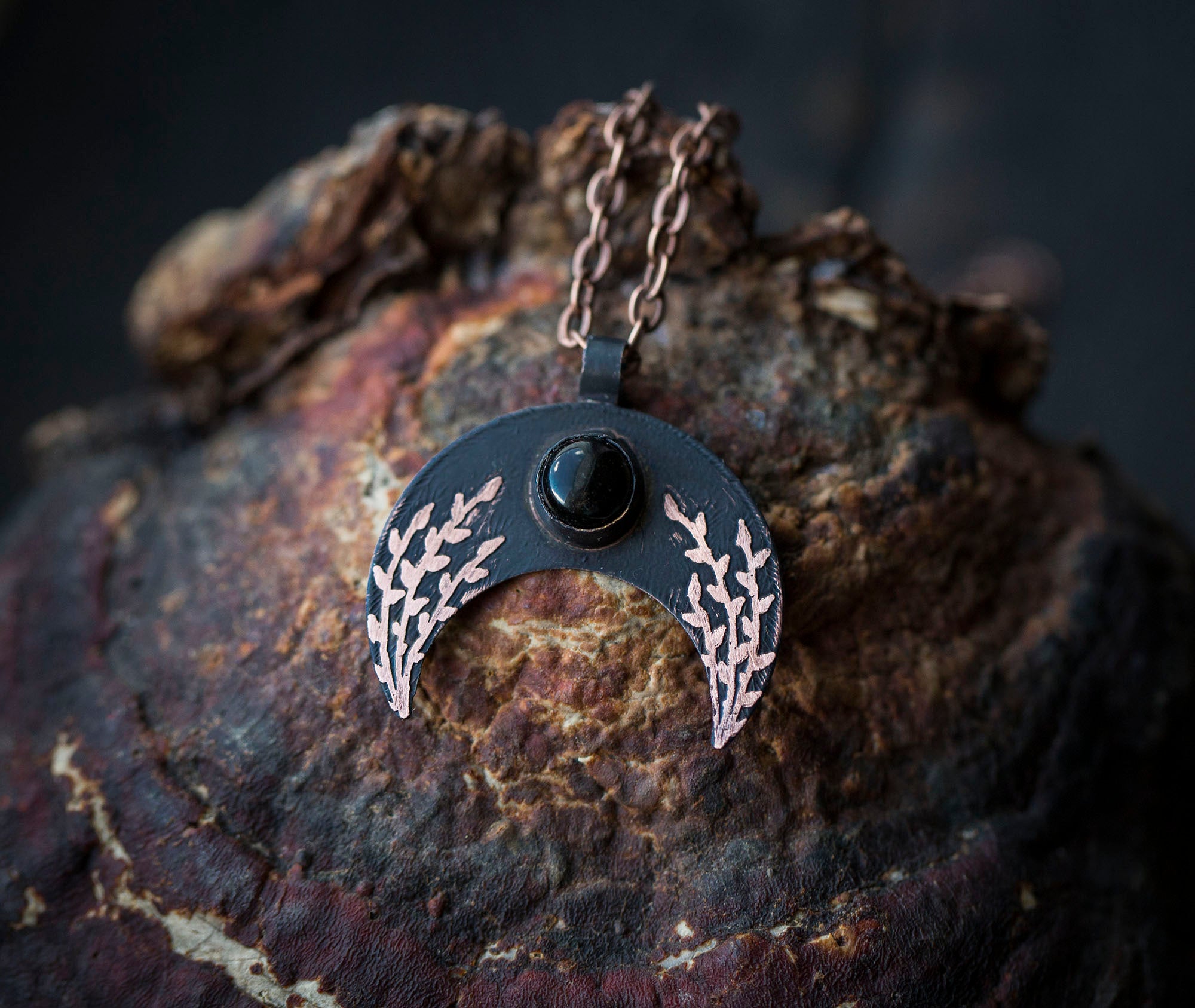 Ciemna lunula z obsydianem i roślinnym rysunkiem