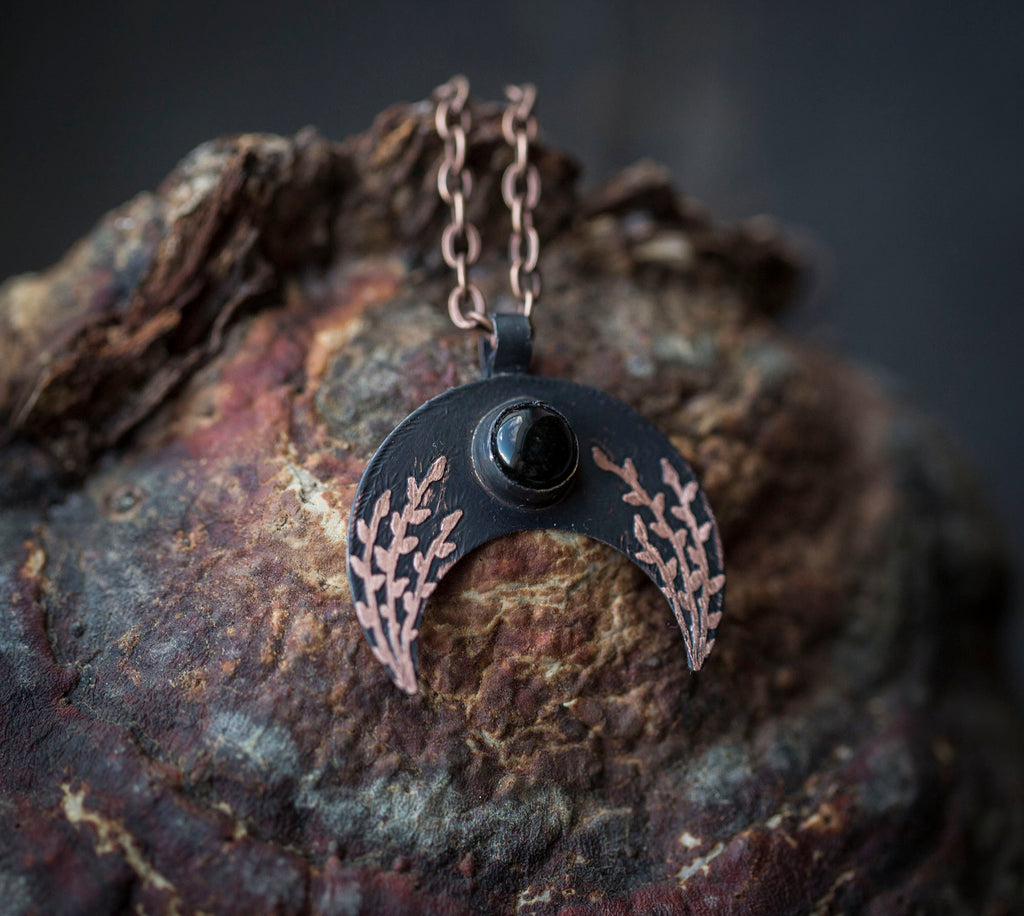 Ciemna lunula z obsydianem i roślinnym rysunkiem