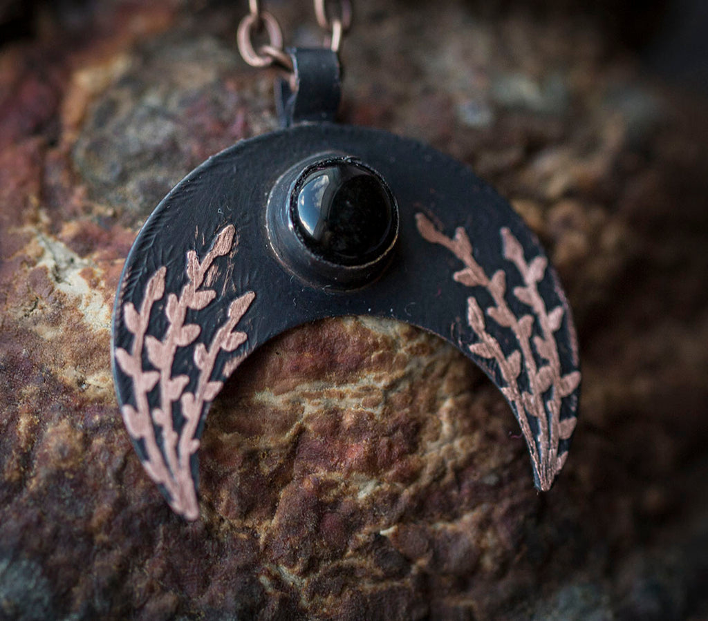 Ciemna lunula z obsydianem i roślinnym rysunkiem