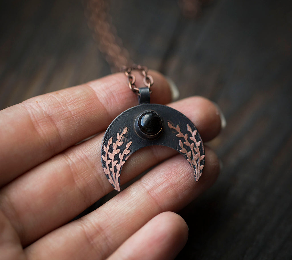 Ciemna lunula z obsydianem i roślinnym rysunkiem