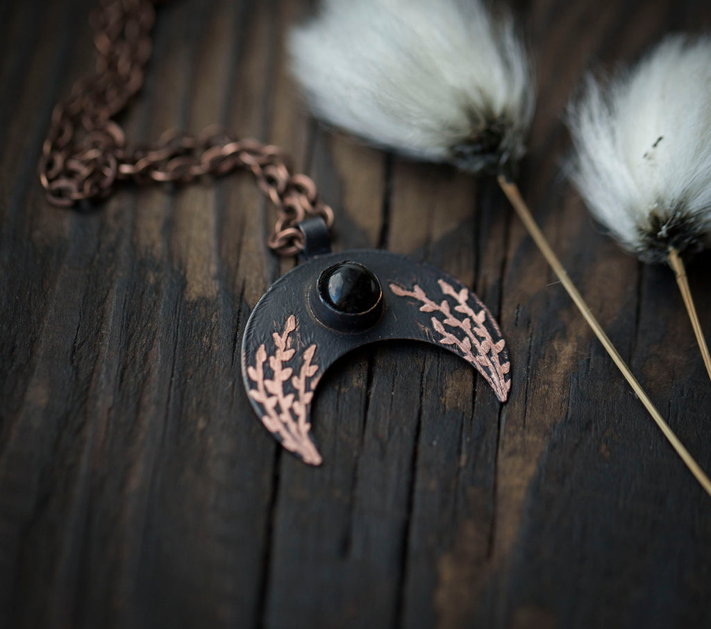 Ciemna lunula z obsydianem i roślinnym rysunkiem