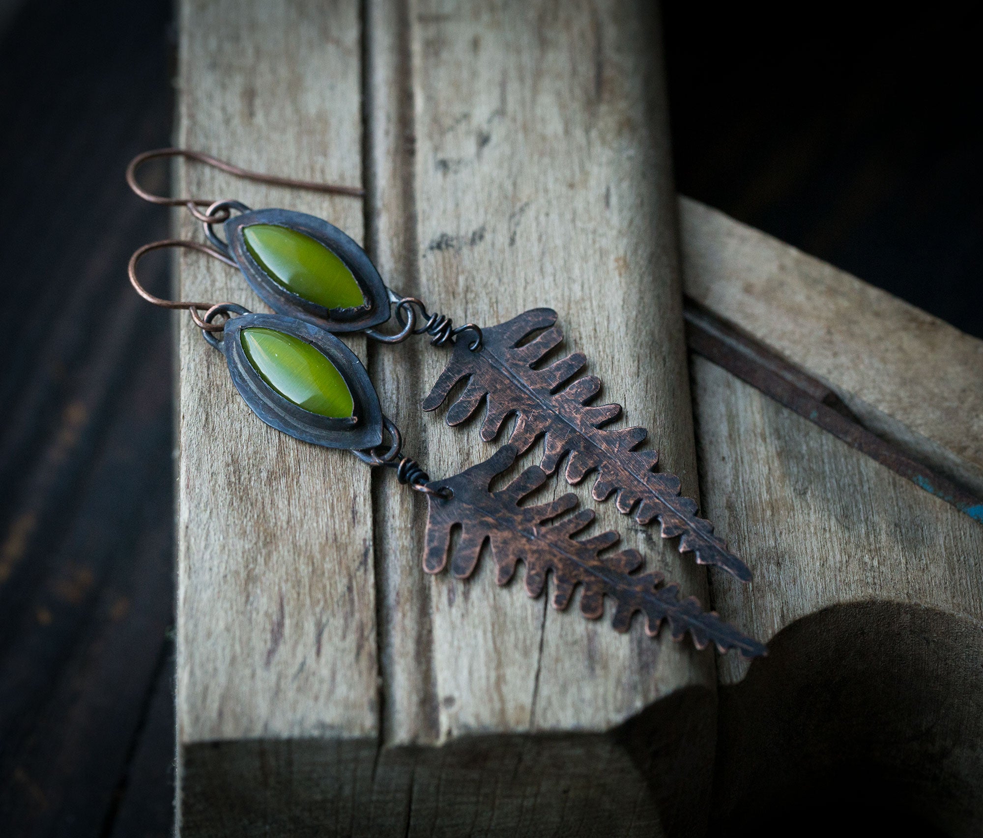 Leśne paprocie kolczyki, długie miedziane liście paproci z zielonym kocim okiem