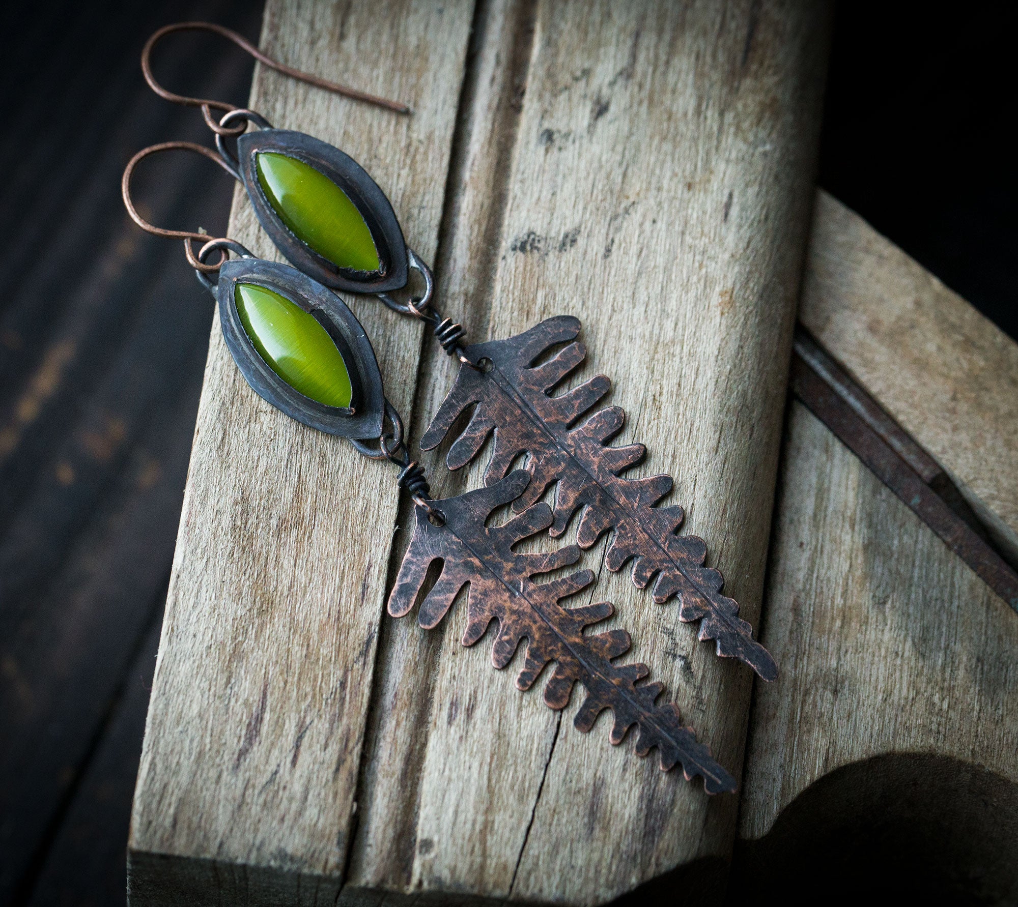 Leśne paprocie kolczyki, długie miedziane liście paproci z zielonym kocim okiem